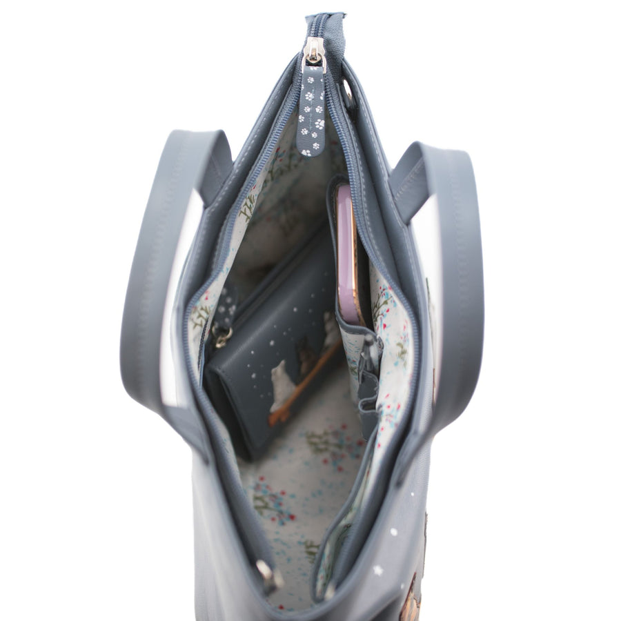 Grey handbag with open interior showing a floral lining and various items.