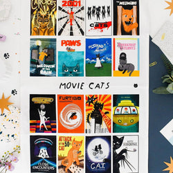 A white tea towel featuring 15 retro-style movie posters themed around cats, titled 'MOVIE CATS'
