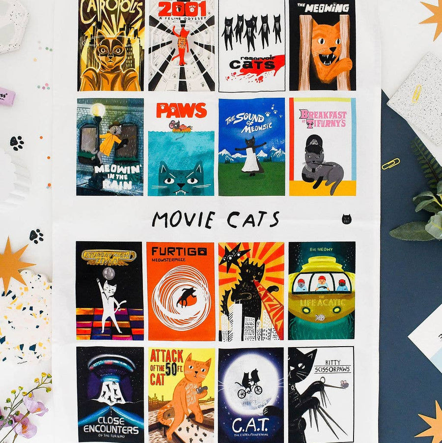 A white tea towel featuring 15 retro-style movie posters themed around cats, titled 'MOVIE CATS'
