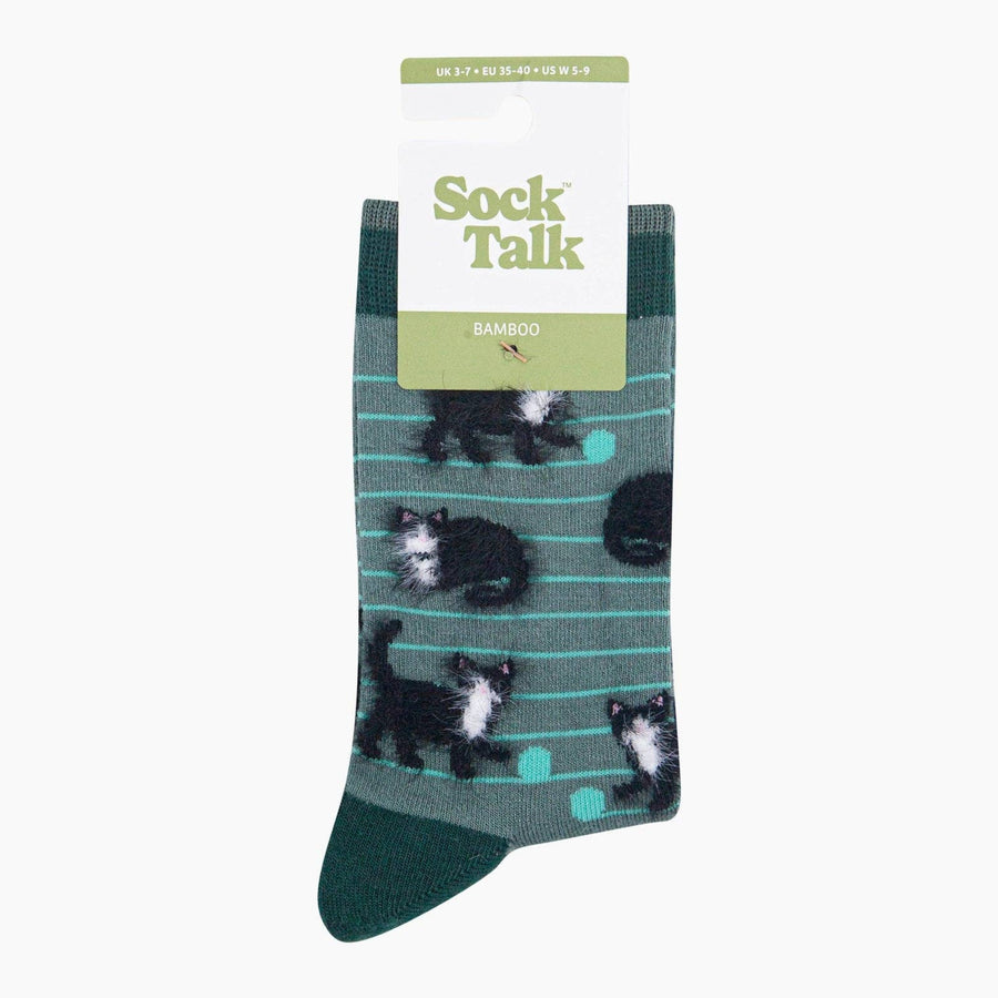 A single Sock Talk bamboo sock in dark green with a pattern of black and white kittens and thin teal stripes