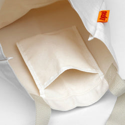 Close-up of a beige pocket with a brand tag on a light gray background