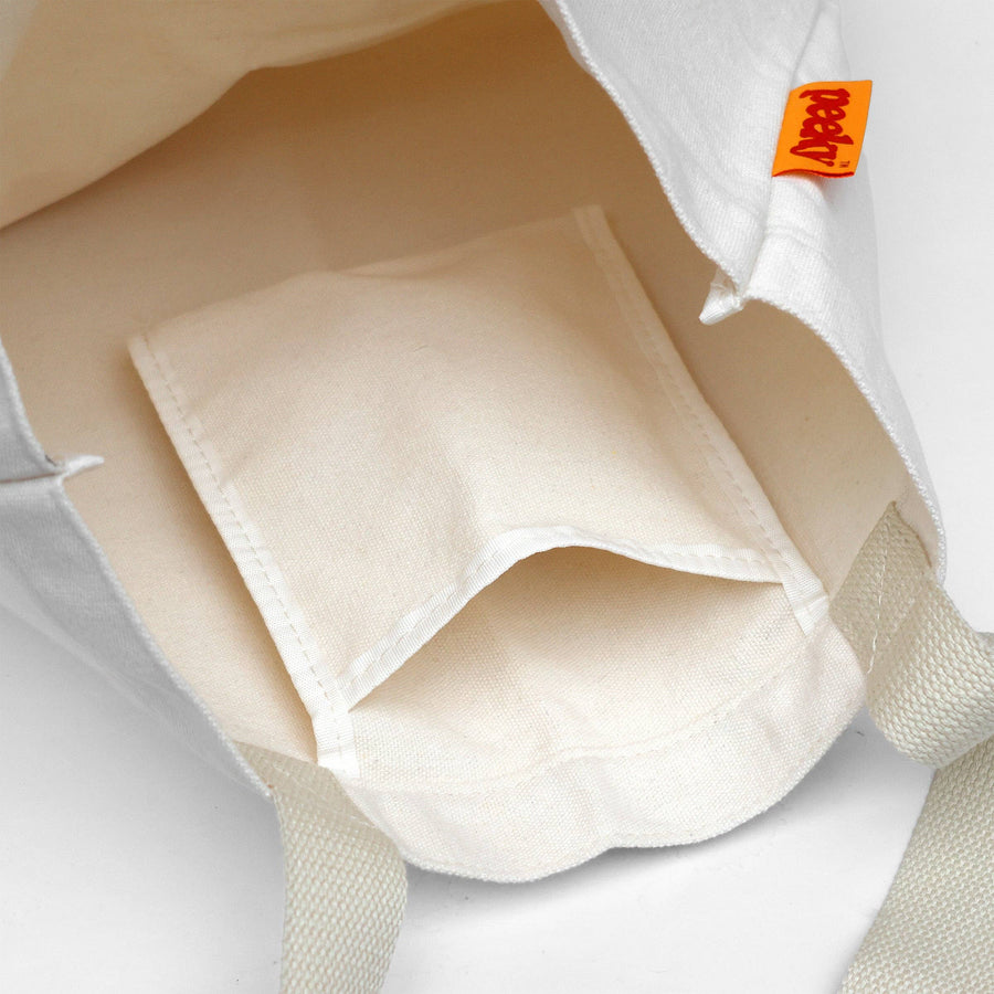 Close-up of a beige pocket with a brand tag on a light gray background