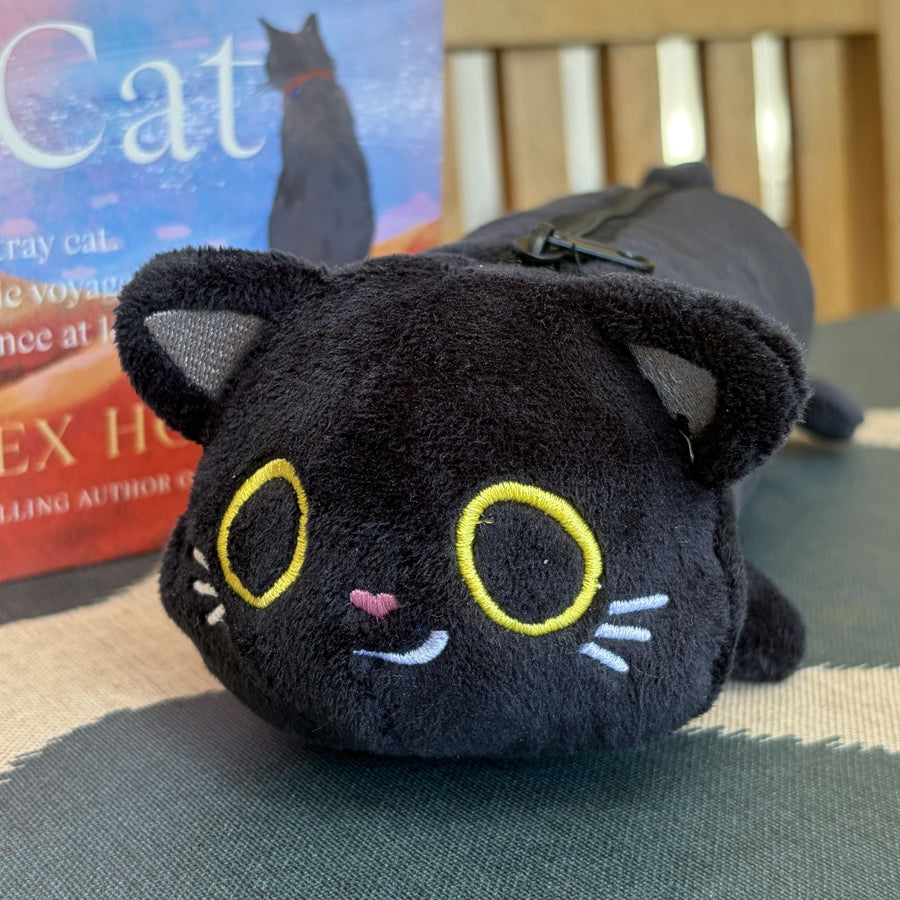 A zippered black plush cat pouch with embroidered yellow eyes, white whiskers, and a small pink nose