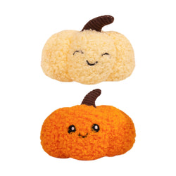 Two plush pumpkin-shaped cat toys with curly textured fabric, one in pale cream and one in bright orange, both with embroidered smiling faces