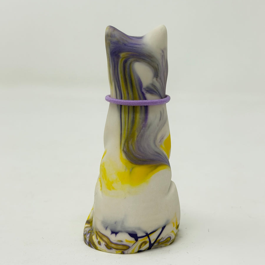 A resin Lucky Cat figuring, shown from the back, with a lilac collar around its neck. The cat has a marbled colour pattern of white, purple, and yellow.