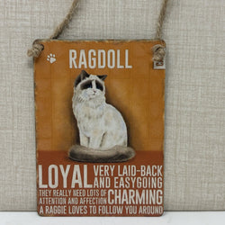 A rustic hanging sign with a painted Ragdoll cat and text reading 'RAGDOLL' and 'LOYAL VERY LAID-BACK AND EASYGOING CHARMING
