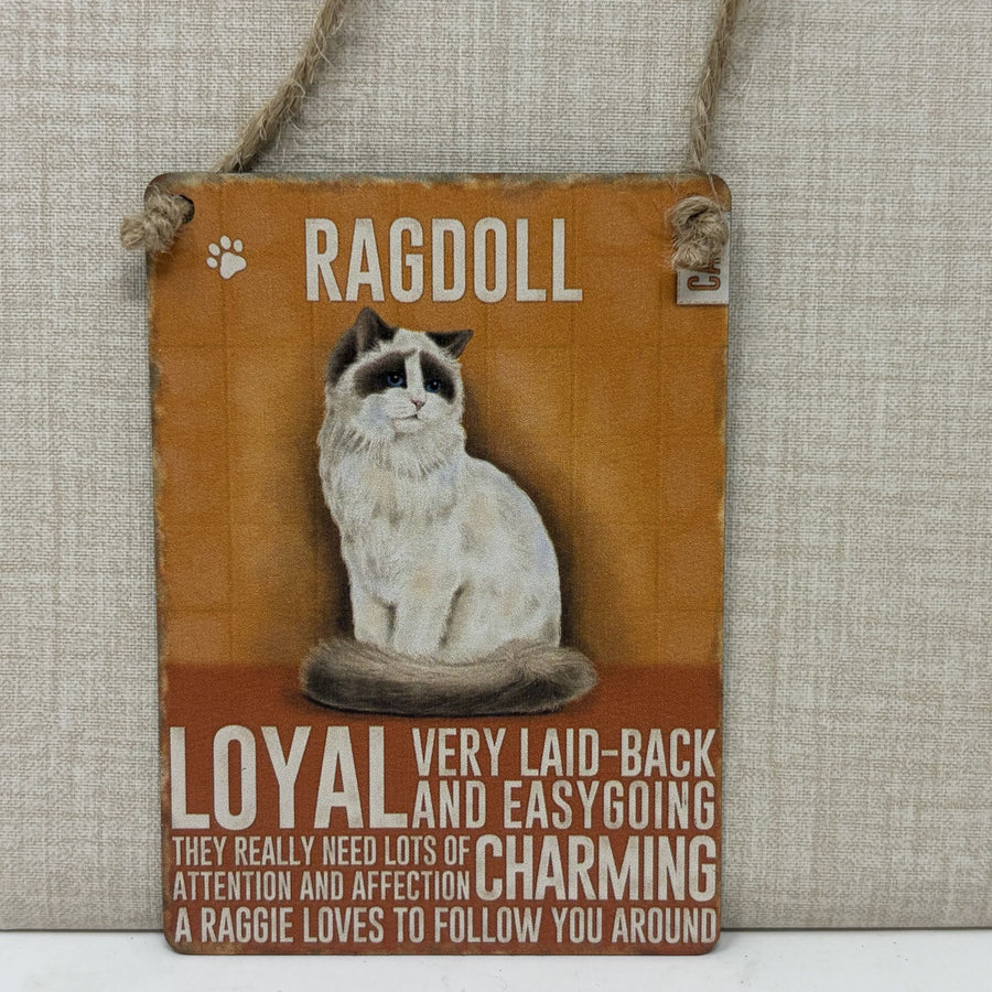 A rustic hanging sign with a painted Ragdoll cat and text reading 'RAGDOLL' and 'LOYAL VERY LAID-BACK AND EASYGOING CHARMING