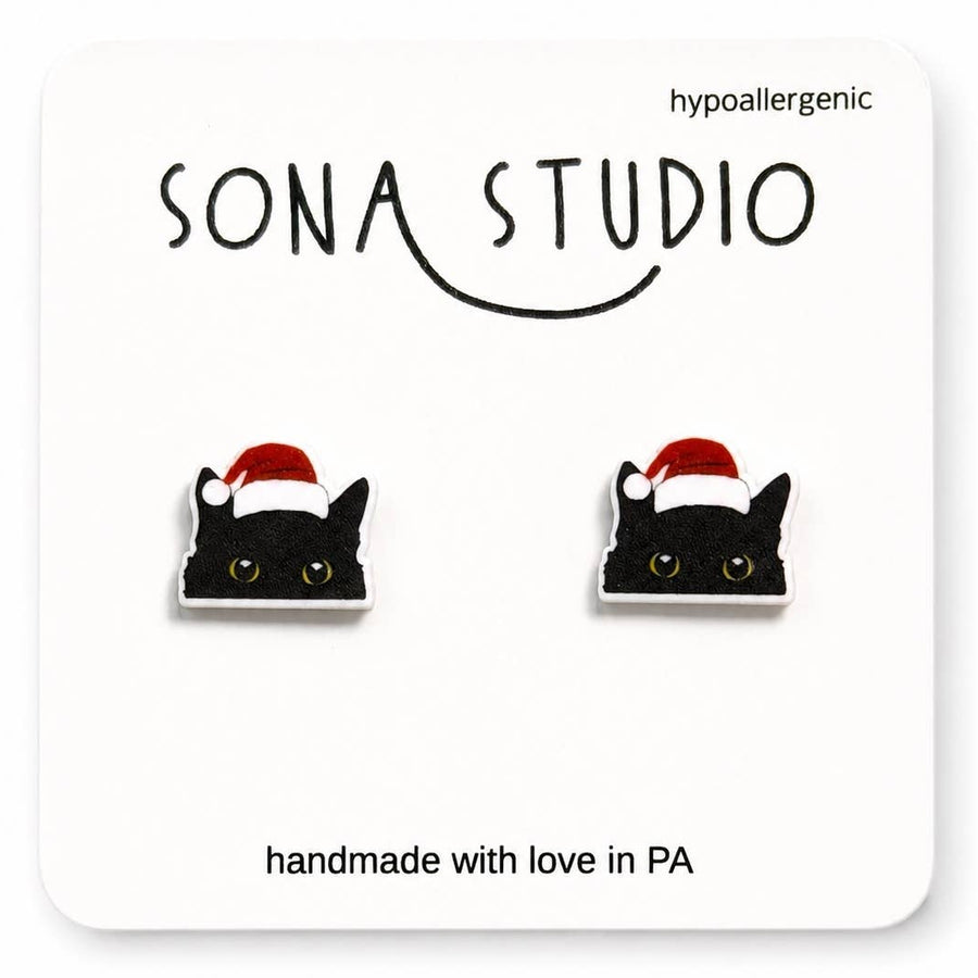 Black cat earrings with Santa hats on a Sona Studio branded card.