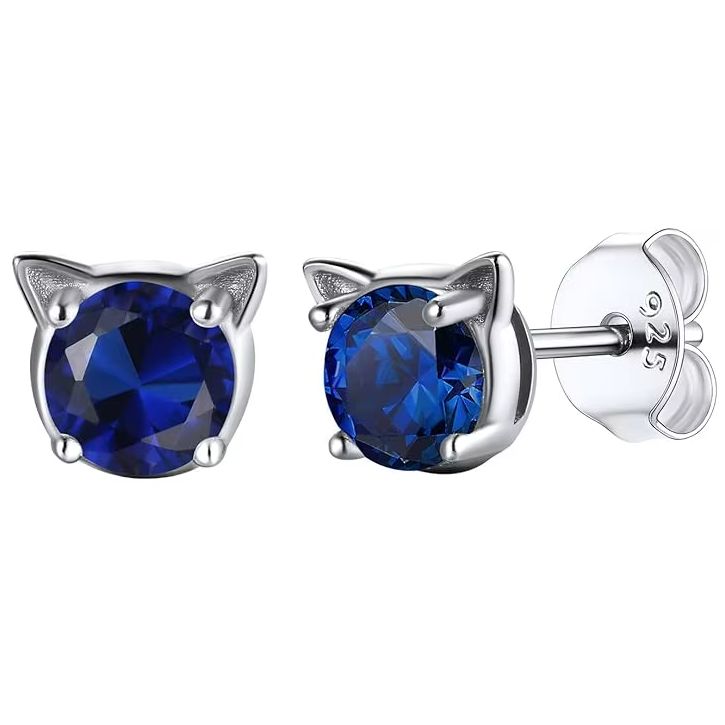 A pair of silver stud earrings in the shape of a cat face with blue birthstone