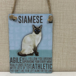 A rectangular hanging sign with a light blue background featuring a photo of a Siamese cat and humorous text about the breed. 