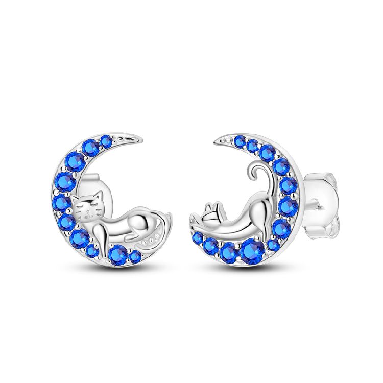 Silver earrings with silver cats and blue gemstones shaped like moons on a white background