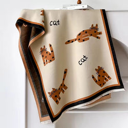 Blanket with ginger orange cat illustrations and text on a white background