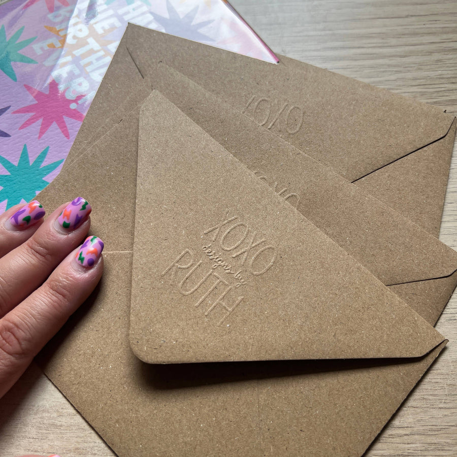 Three brown kraft paper envelopes with embossed 'XOXO forever by RUTH' text, 