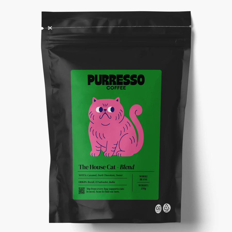 A black stand-up coffee bag with a green label featuring a pink cat illustration and text 'PURRESSO COFFEE' and 'The House Cat - Blend'
