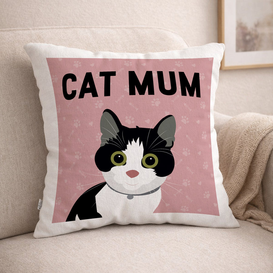 Decorative cushion with a black and white tuxedo cat illustration and 'CAT MUM' text on a pink background, placed on a beige couch.