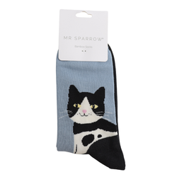 A pair of light blue bamboo socks with a black and white tuxedo cat graphic