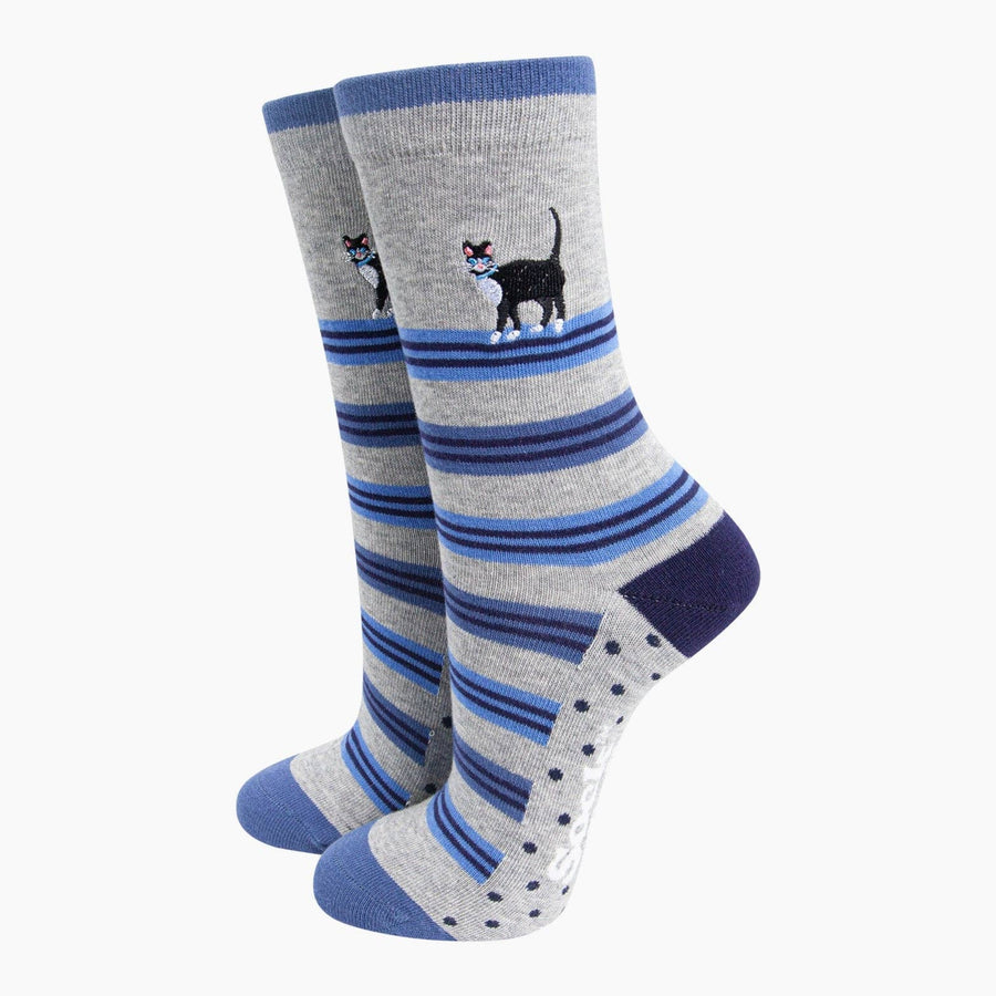 Pair of grey socks with blue stripes and a cat design on a white background