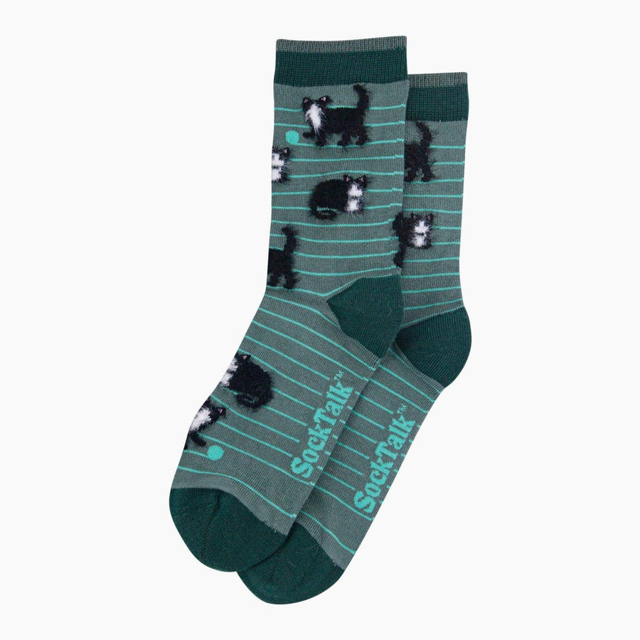 A pair of crew socks in dark green with thin teal stripes, featuring black and white cat illustrations