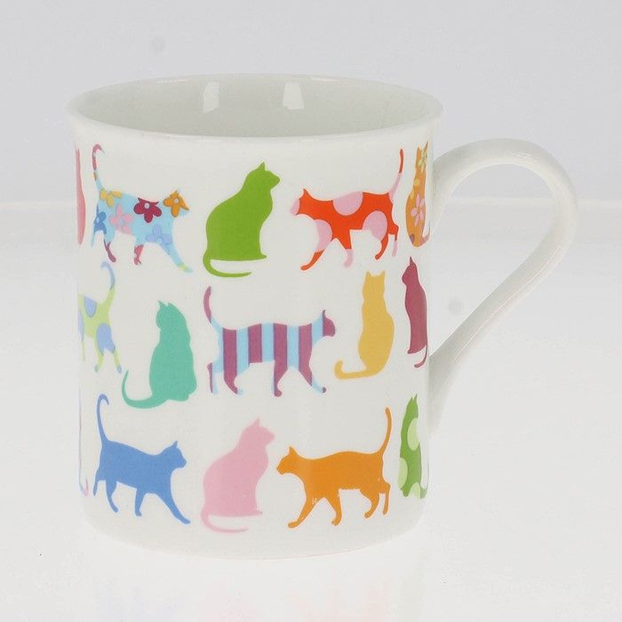 A white ceramic mug decorated with a colourful pattern of various cat silhouettes in different colours and patterns