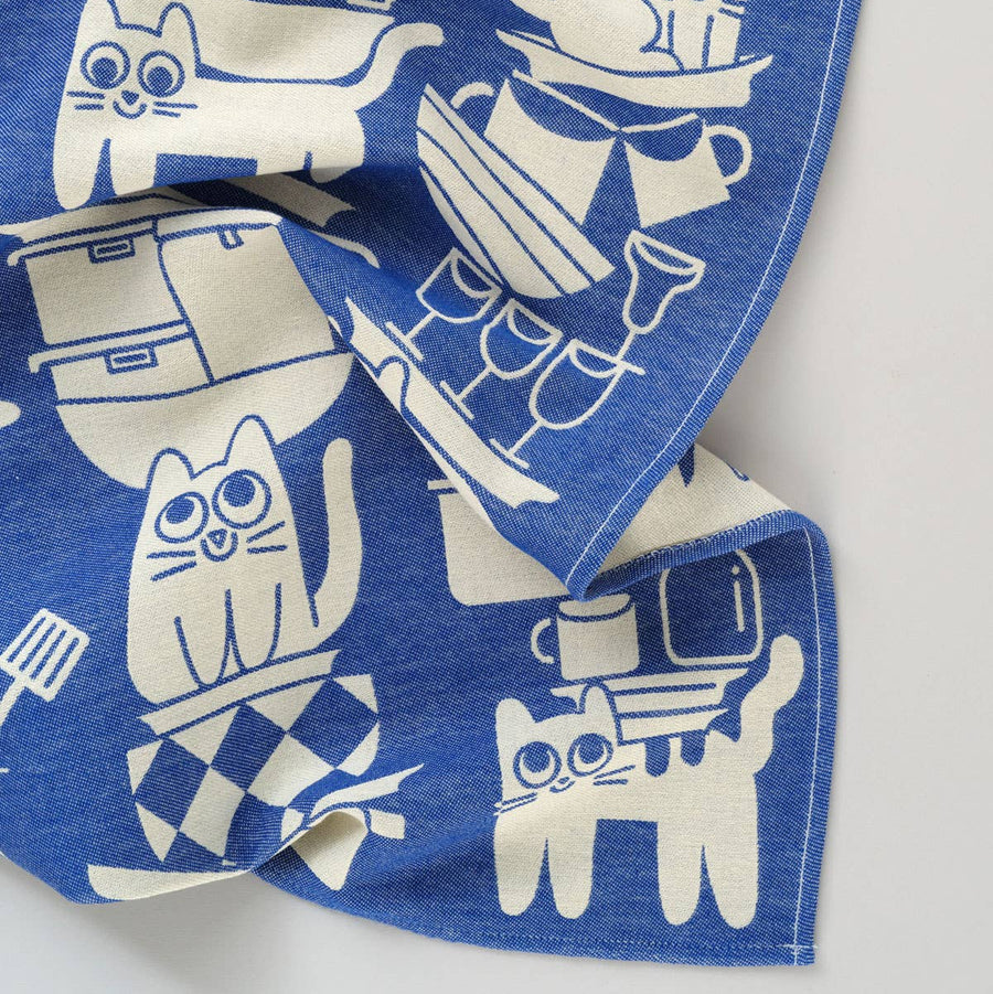 Blue fabric with white cat illustrations on a white background