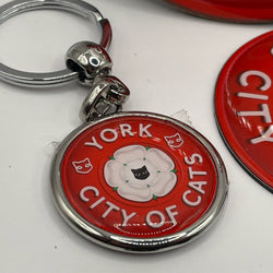 Metal keyring with circular charm saying "York City of Cats" with black cat face in Yorkshire rose on red background 