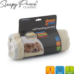ANCOL Sleepy Paws Classic self-heating pet pad in its retail packaging, showing a rolled cream-colored fleece pad with a black header card. The packaging features a picture of a cat and dog resting on the pad, along with feature icons for self-heating, washable, and removable cover.