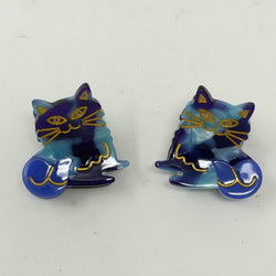 A pair of blue / purple shade hair claws in the form of cats on a white background