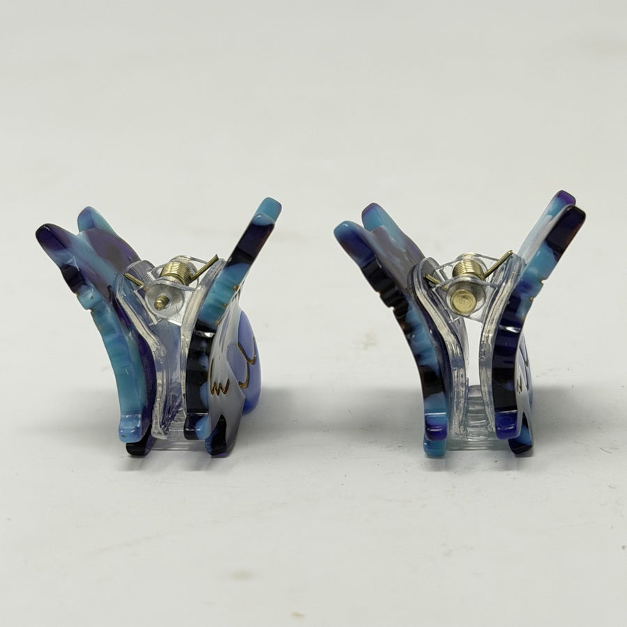 Pair of butterfly-shaped cat hair claws, side view