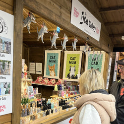 The Cat Gallery wooden Christmas Chalet showing our Christmas Cat Garland hanging across the counter