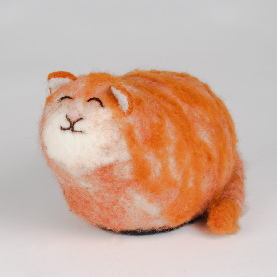 A hand-felted, ginger cat shaped LED night light, with a smiling face and black ears.