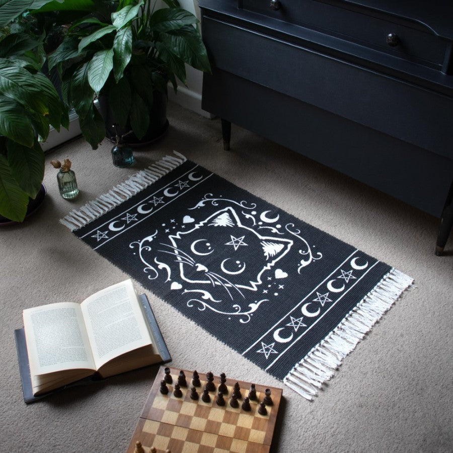 Lifestyle setting for a Black rug with white tassels with mystical white cat motif featuring pentagram stars and moons
