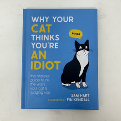 The book 'Why Your Cat Thinks You're An Idiot' by Sam Hart, illustrated by Fin Kendall, featuring a bright blue cover with a black and white cat illustration and yellow text accents.