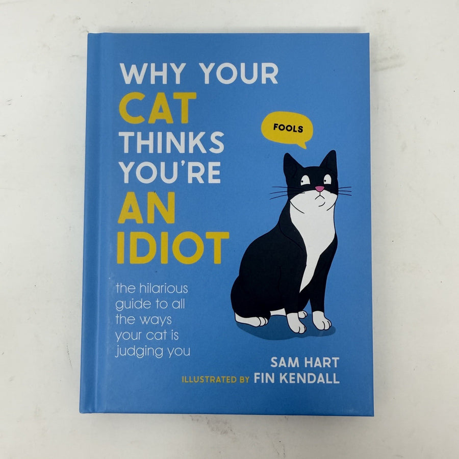 The book 'Why Your Cat Thinks You're An Idiot' by Sam Hart, illustrated by Fin Kendall, featuring a bright blue cover with a black and white cat illustration and yellow text accents.