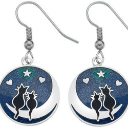 A pair of silver-coloured enamel earrings featuring a cat silhouette with a moon and stars design on a blue background